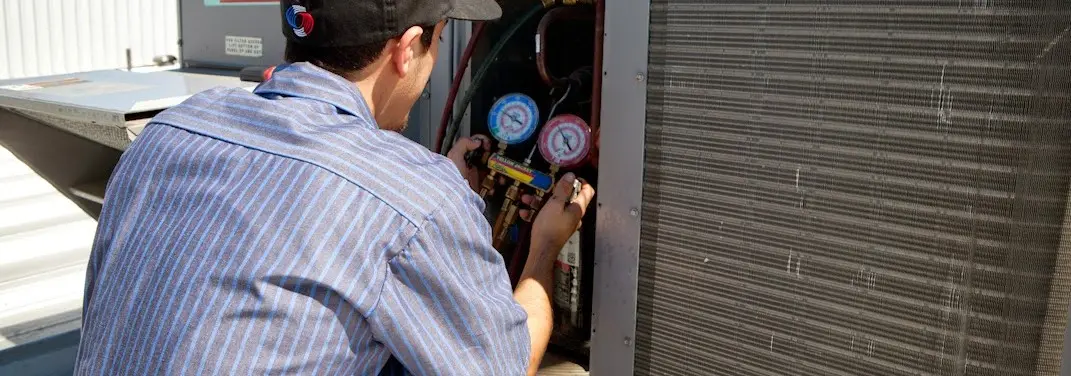 HVAC technician servicing a condenser unit in Charlotte