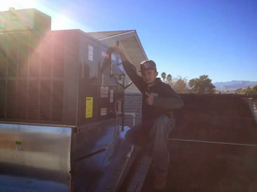 HVAC technician performing Air Duct Repair on a rooftop unit in Charlotte